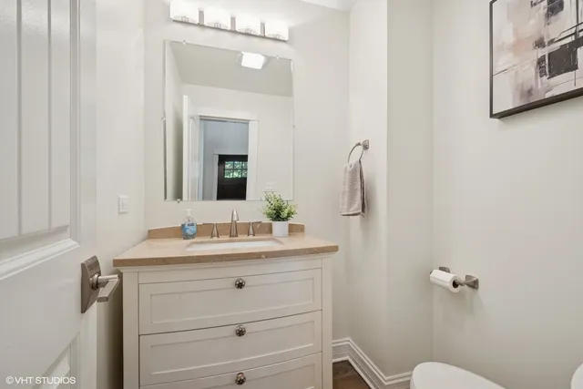 a bathroom with a sink vanity mirror and toilet
