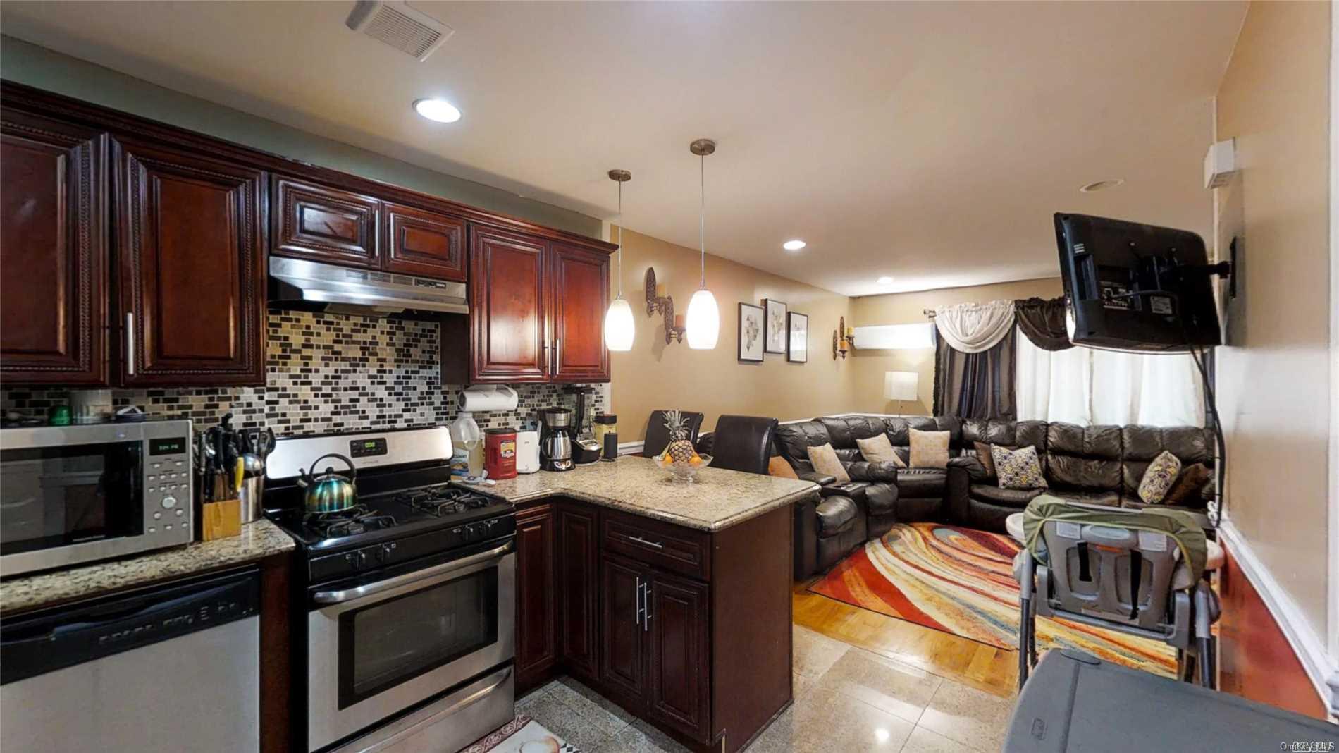 176-32 133rd Road Queens, NY 11434 - Photo 4 of 11 a kitchen with stainless steel appliances granite countertop a stove a sink and a microwave