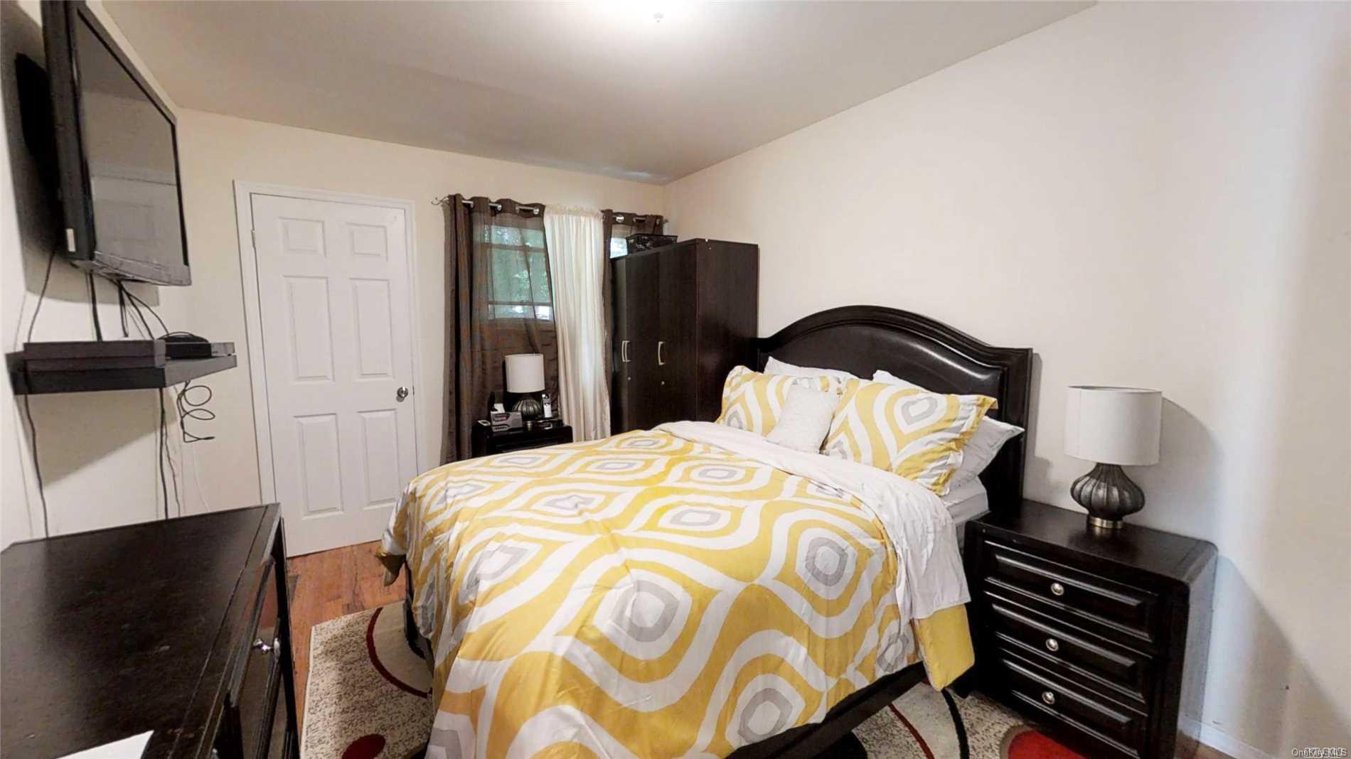 176-32 133rd Road Queens, NY 11434 - Photo 8 of 11 a bedroom with a bed and flat tv screen on the dresser