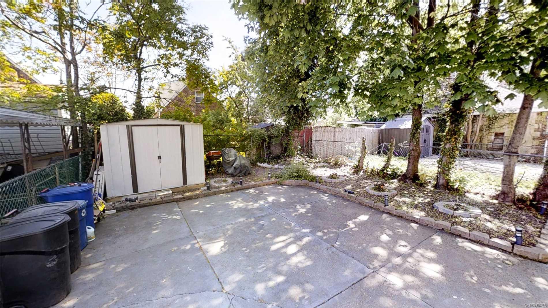 176-32 133rd Road Queens, NY 11434 - Photo 10 of 11 a view of a backyard with large trees and a barn