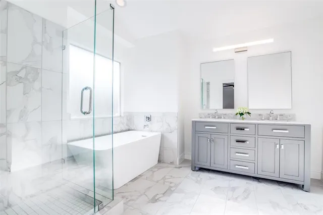 a bathroom with a double vanity sink a mirror a bathtub and shower