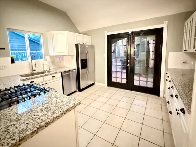 a kitchen with stainless steel appliances kitchen island granite countertop a refrigerator and a stove top oven