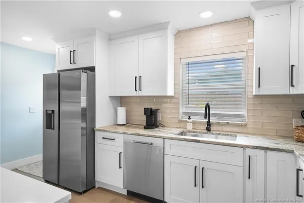 a kitchen with stainless steel appliances granite countertop a refrigerator sink and cabinets