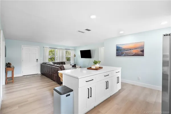 a large white room with mirror on the wall and a wooden floor