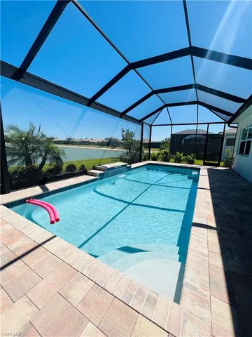a view of a backyard with table and chairs under an umbrella