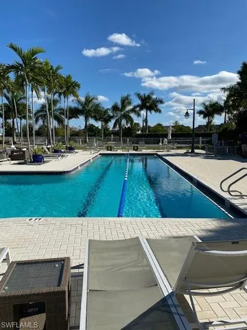 a view of a swimming pool with a lounge chair and tables