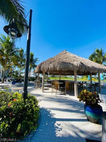 a view of a patio with table and chairs potted plants and large tree