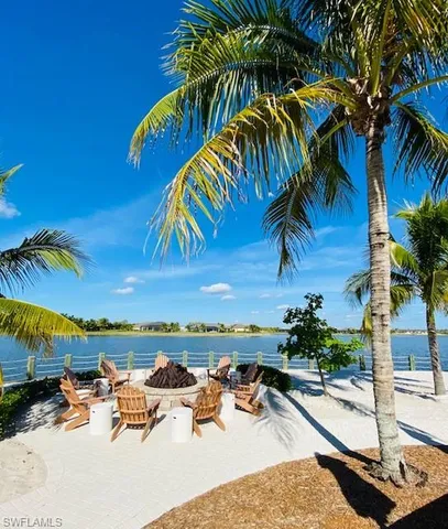 a view of a swimming pool with a lawn chairs under palm trees