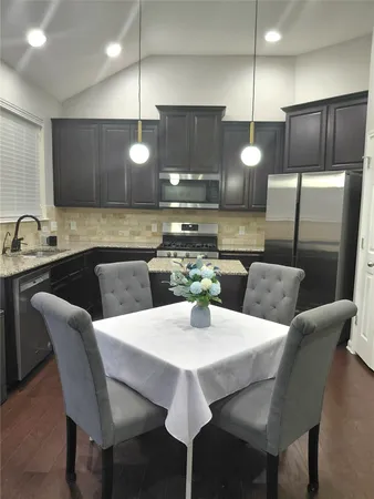 a kitchen with a dining table chairs and a refrigerator