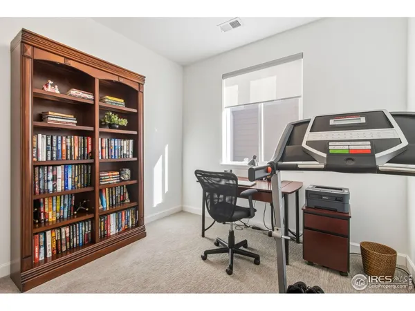 a view of a workspace with furniture and a bookshelf