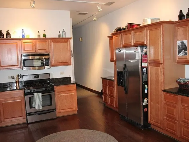 a kitchen with stainless steel appliances and wooden cabinets