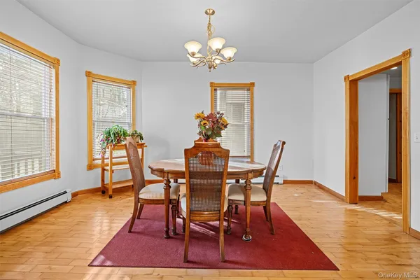 a view of a dining room with furniture a chandelier and wooden floor