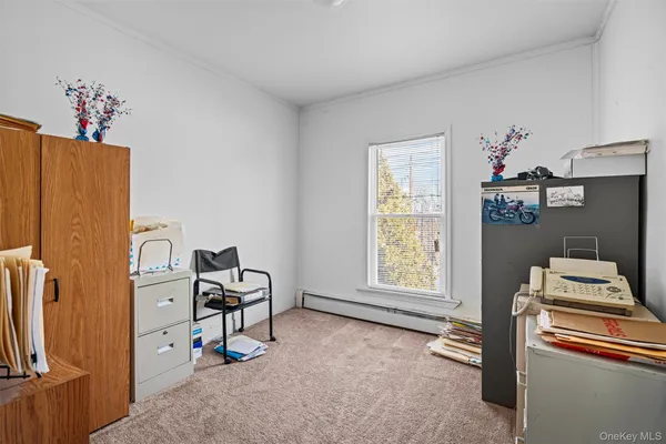 a view of a workspace with furniture and a window