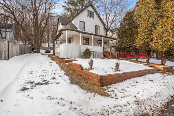 a front view of a house with a yard covered in snow