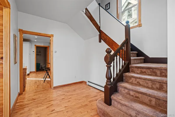 a view of entryway and hall with wooden floor