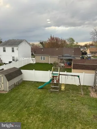 a view of a swimming pool with a lawn chairs and a big yard
