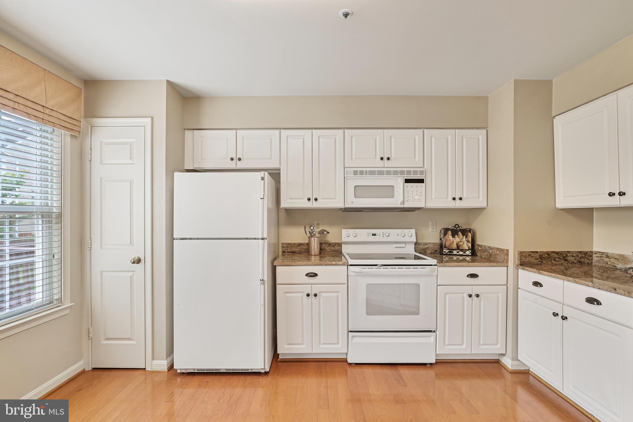 2128 Elm Tree Lane Silver Spring, MD 20906 - Photo 16 of 55 a kitchen with white cabinets and white appliances