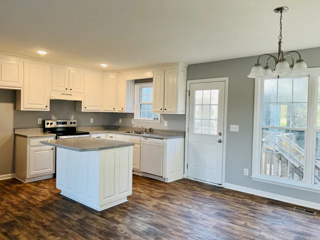 a kitchen with a sink cabinets and wooden floor