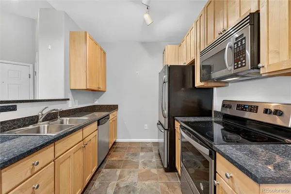 a kitchen with stainless steel appliances granite countertop a sink and a stove