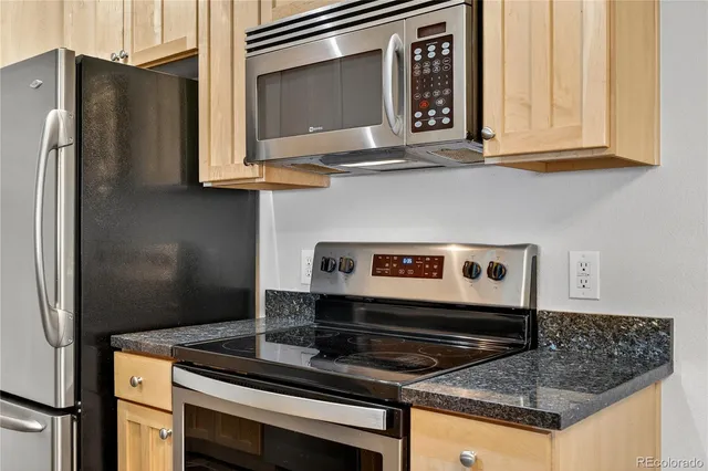 a kitchen with stainless steel appliances granite countertop a stove and a microwave