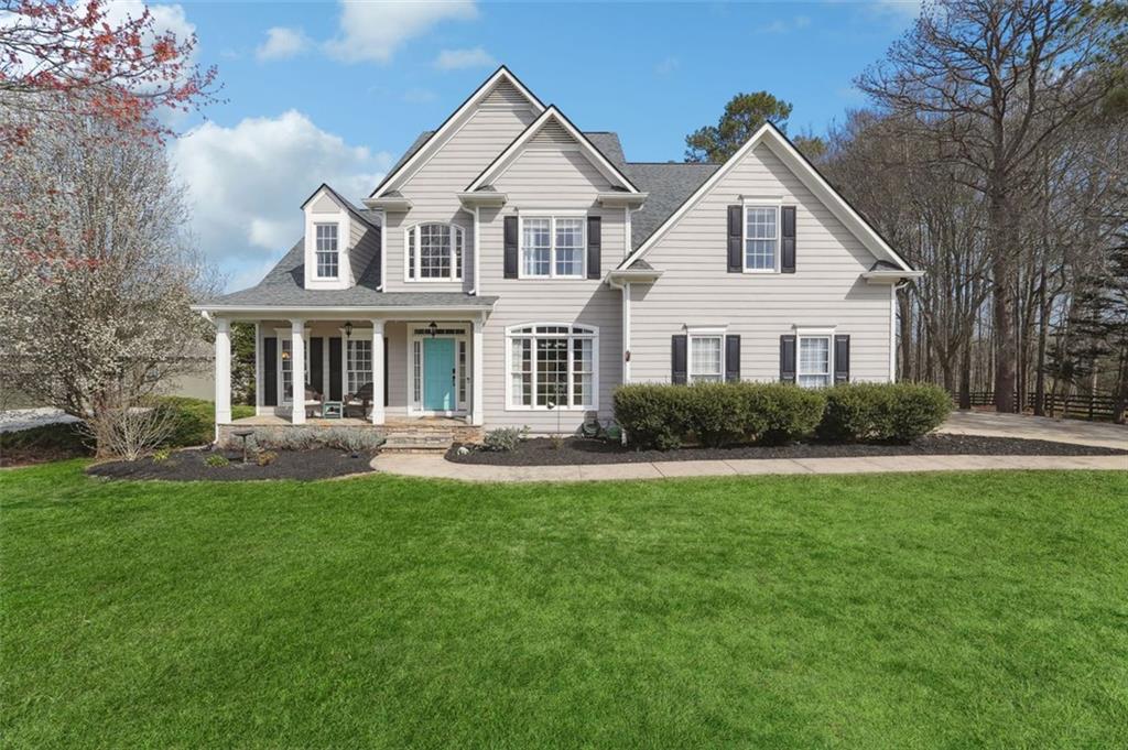 a front view of a house with a garden and trees