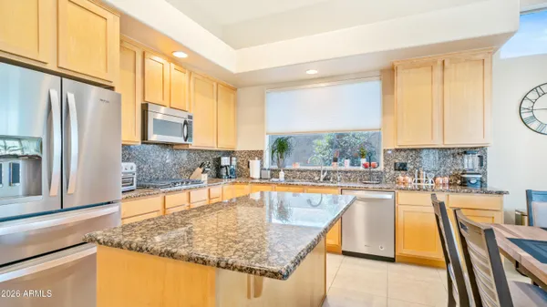 a kitchen with stainless steel appliances granite countertop sink stove and refrigerator