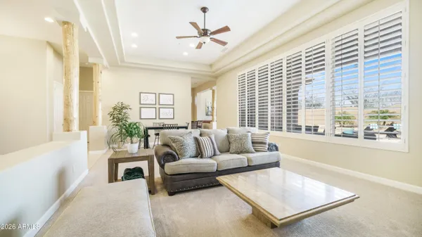 a living room with furniture and a large window with wooden floor