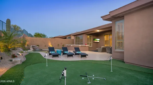 a view of house with backyard and outdoor seating