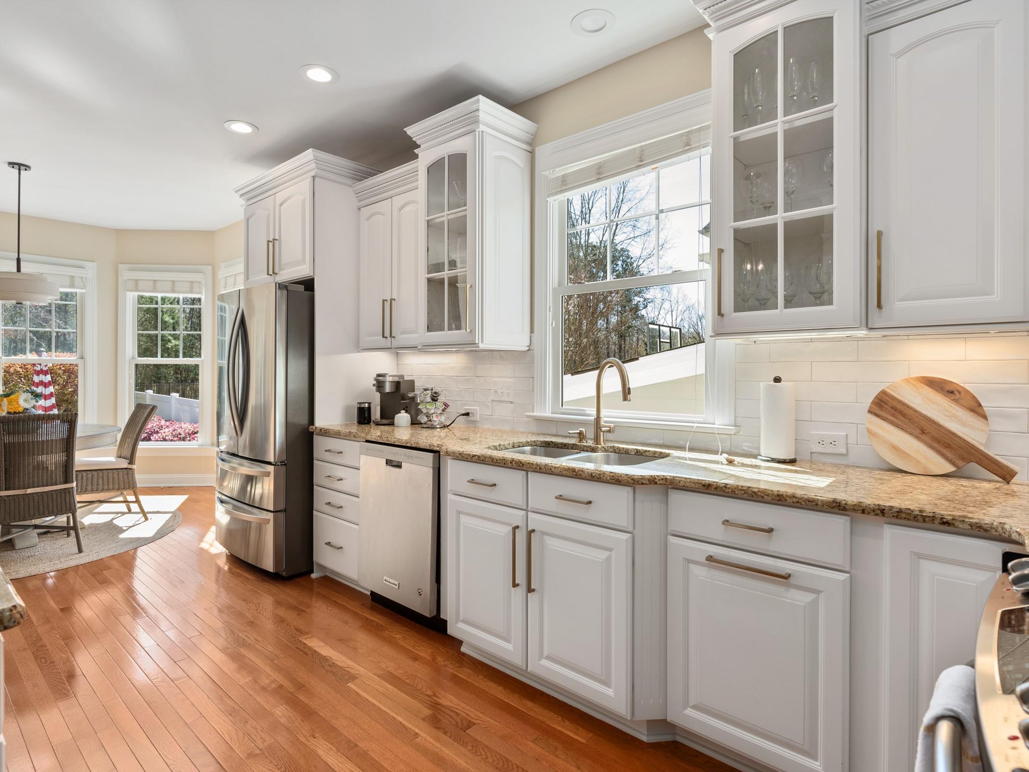 4300 Birkshire Heights Fort Mill, SC 29708 - Photo 9 of 40 a kitchen with stainless steel appliances granite countertop a refrigerator a sink dishwasher a stove and white cabinets with wooden floor