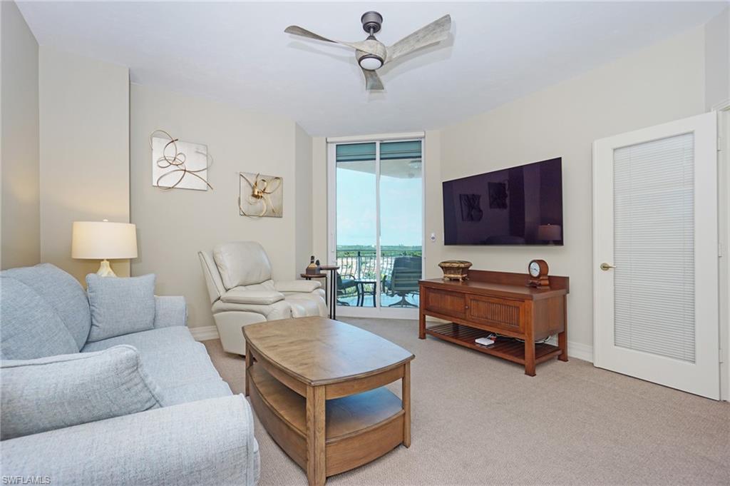 435 Dockside Drive, Unit B803 Naples, FL 34110 - Photo 21 of 35 Carpeted living room with expansive windows and ceiling fan