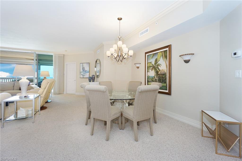 435 Dockside Drive, Unit B803 Naples, FL 34110 - Photo 6 of 35 Dining area with crown molding, light colored carpet, and a notable chandelier