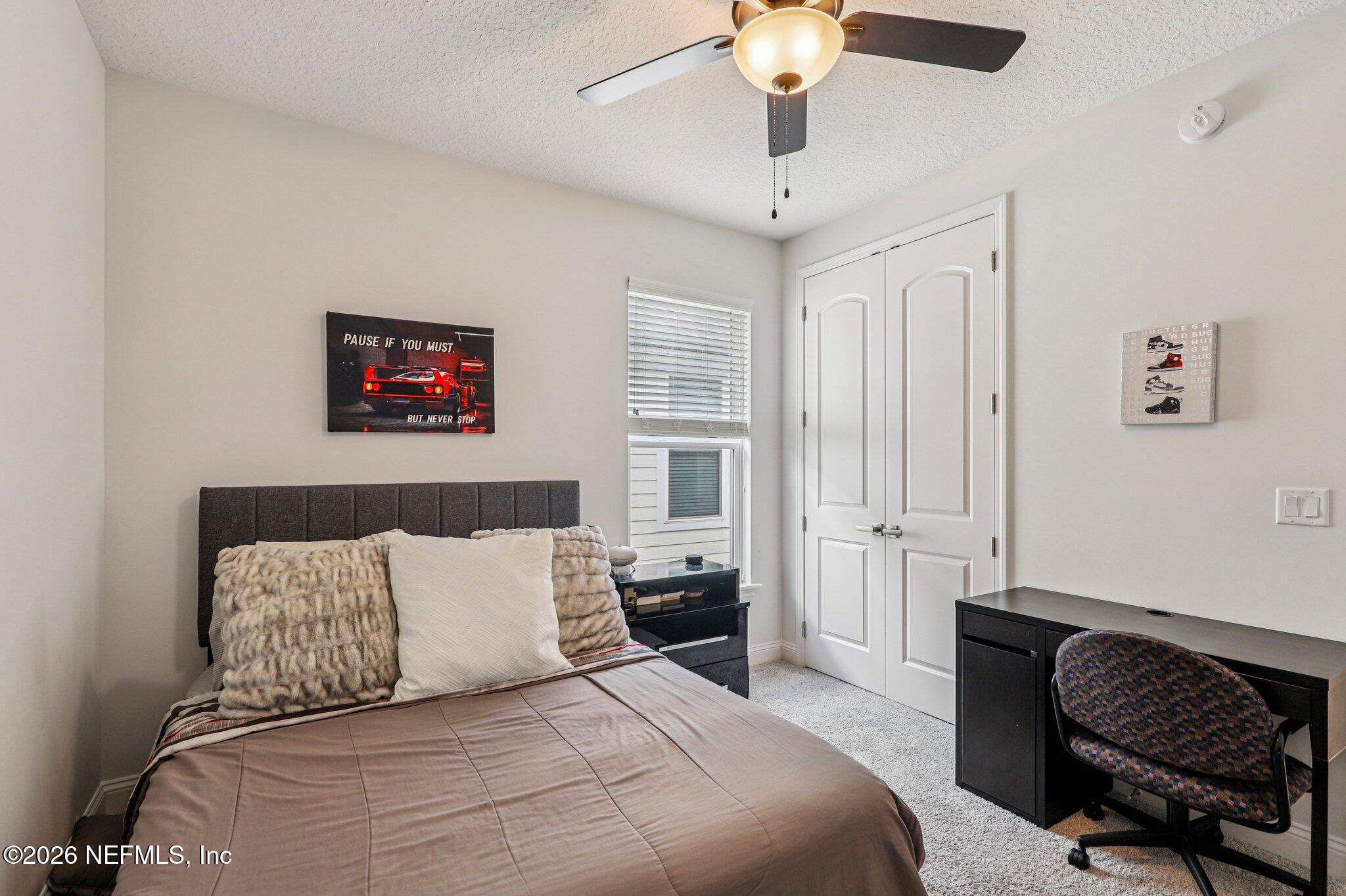 84 Firecrest Drive St. Augustine, FL 32092 - Photo 28 of 72 a bedroom with a bed and a chandelier