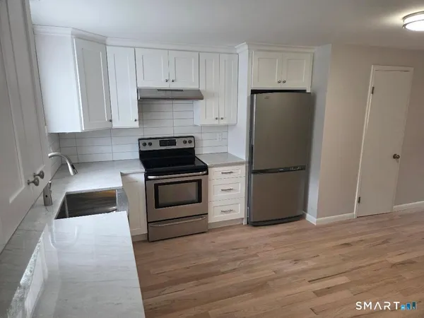 a kitchen with a refrigerator stove and white cabinets