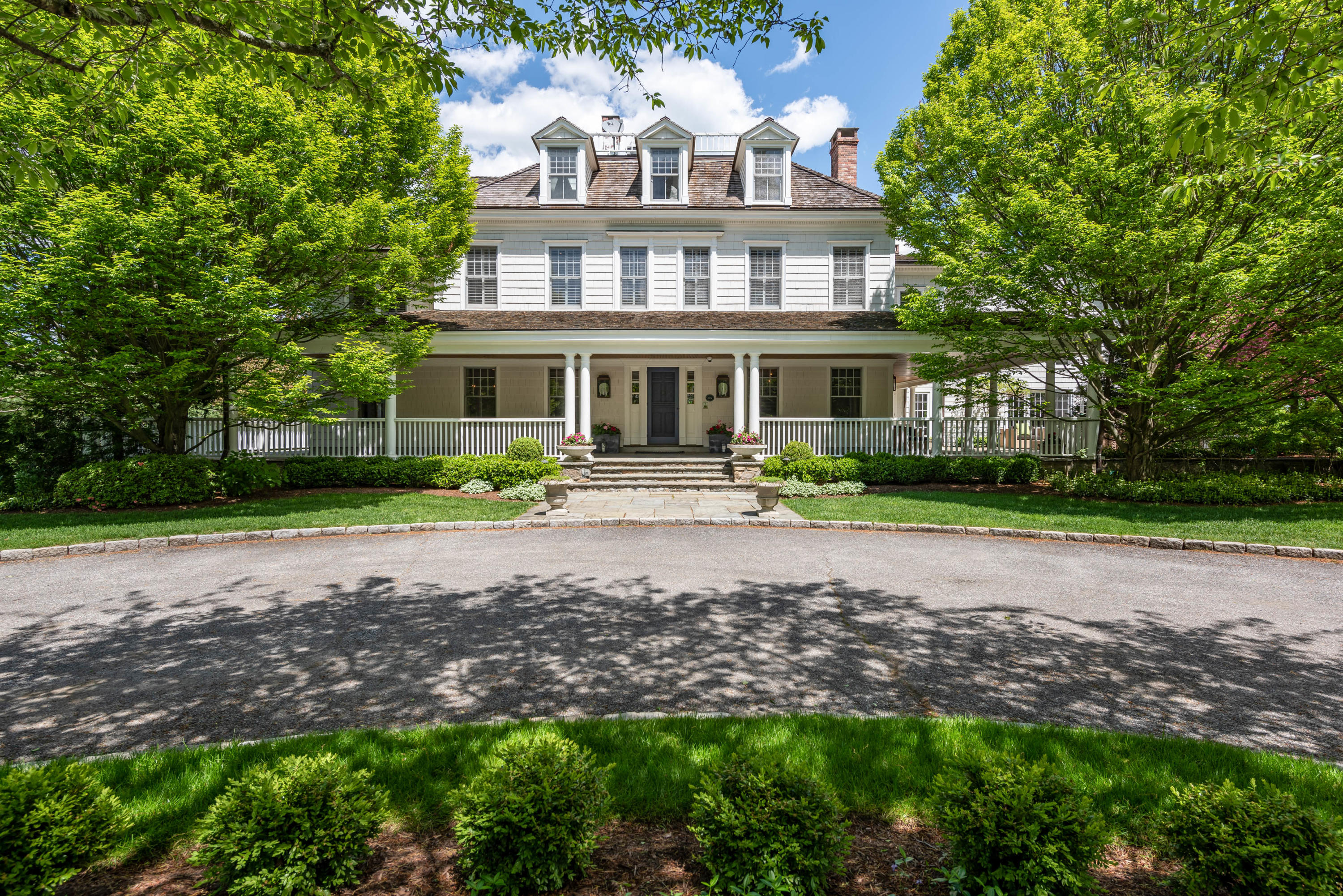 289 Oenoke Ridge New Canaan, CT 06840 - Photo 2 of 39 a front view of a house with garden