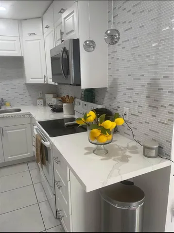 a kitchen with a sink a stove and cabinets
