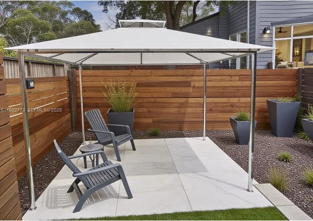 a view of a patio with table and chairs and wooden fence