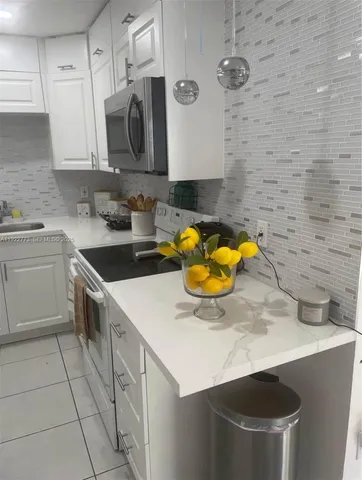 a kitchen with a sink a stove and cabinets
