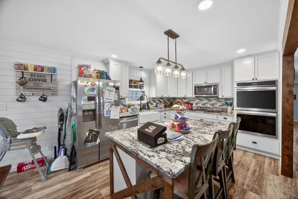 a kitchen with stainless steel appliances granite countertop a sink dishwasher and cabinets with wooden floor