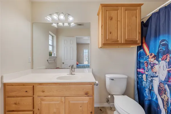 a bathroom with a toilet sink and mirror