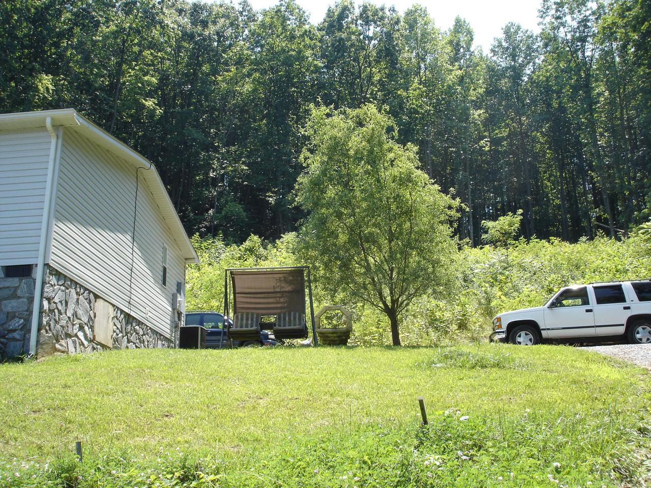 4141 Mountain View Church Road Blue Ridge, VA 24064 - Photo 5 of 13 a backyard of a house with table and chairs and a large tree