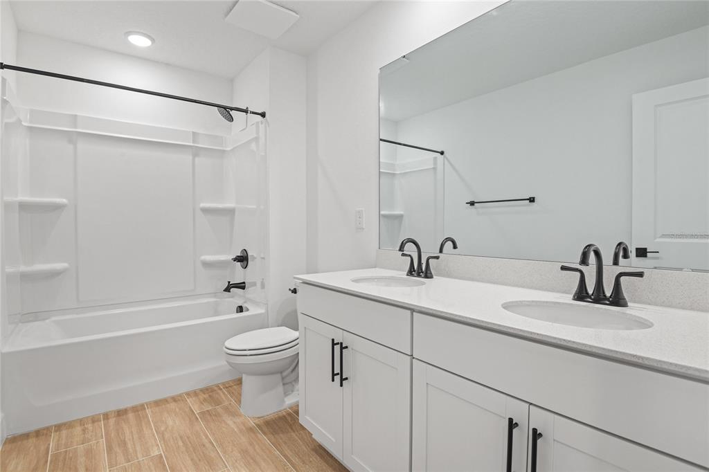 151 Waterstone Loop Tavares, FL 32778 - Photo 11 of 20 a bathroom with a sink a toilet and a large mirror