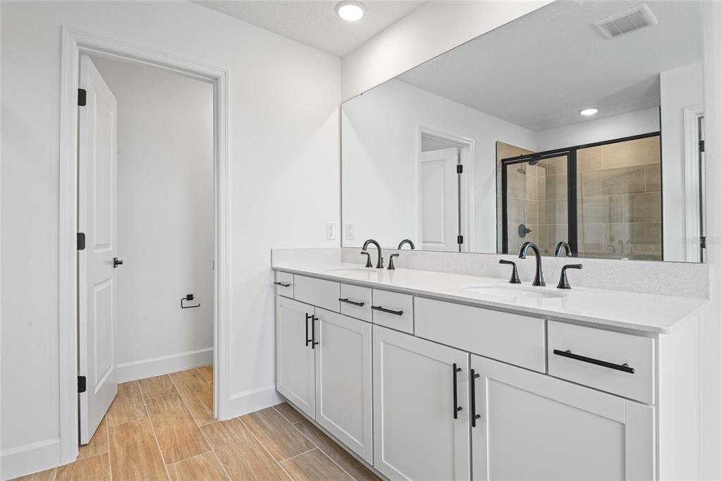 151 Waterstone Loop Tavares, FL 32778 - Photo 16 of 20 a spacious bathroom with a double vanity sink mirror and