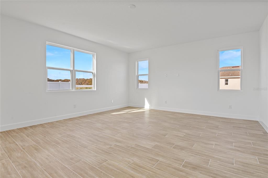 151 Waterstone Loop Tavares, FL 32778 - Photo 8 of 20 a view of an empty room with wooden floor and a window
