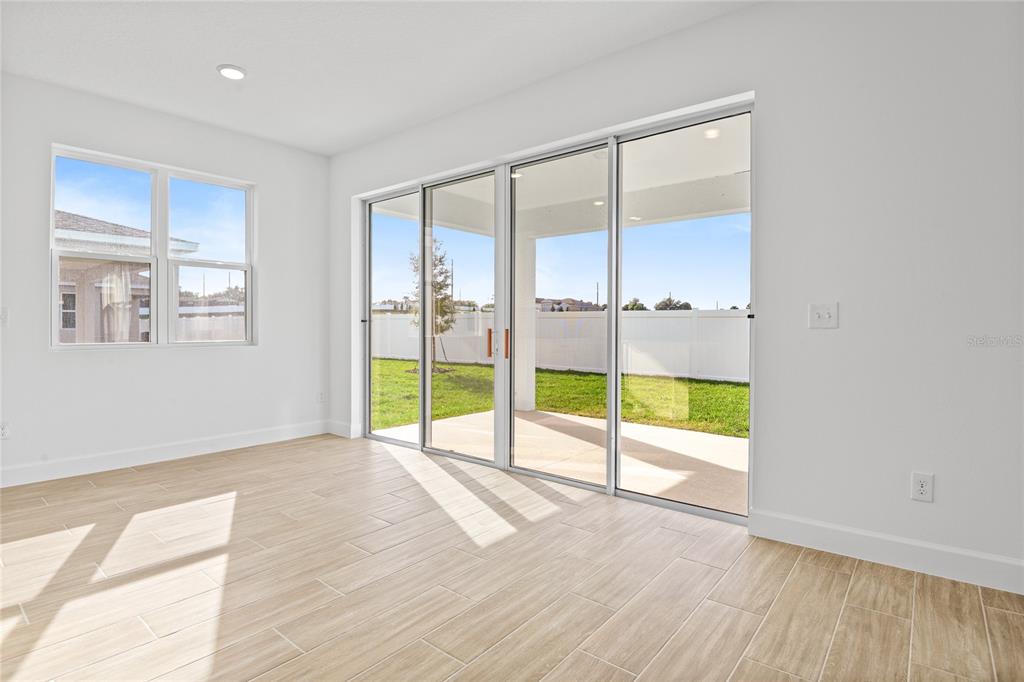 151 Waterstone Loop Tavares, FL 32778 - Photo 9 of 20 a view of an empty room with a floor to ceiling window and wooden floor