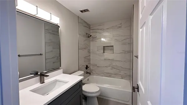 a bathroom with a sink toilet tub and shower