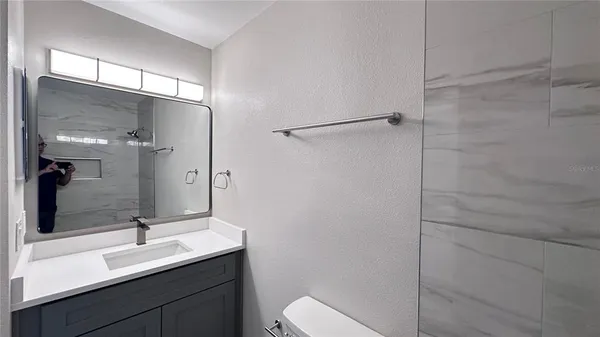 a bathroom with a sink a toilet and shower