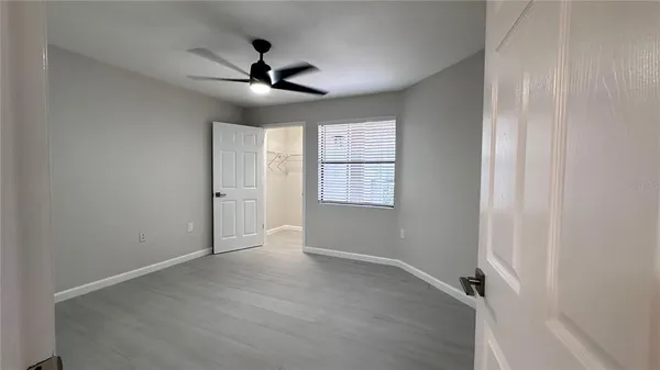 an empty room with windows and fan