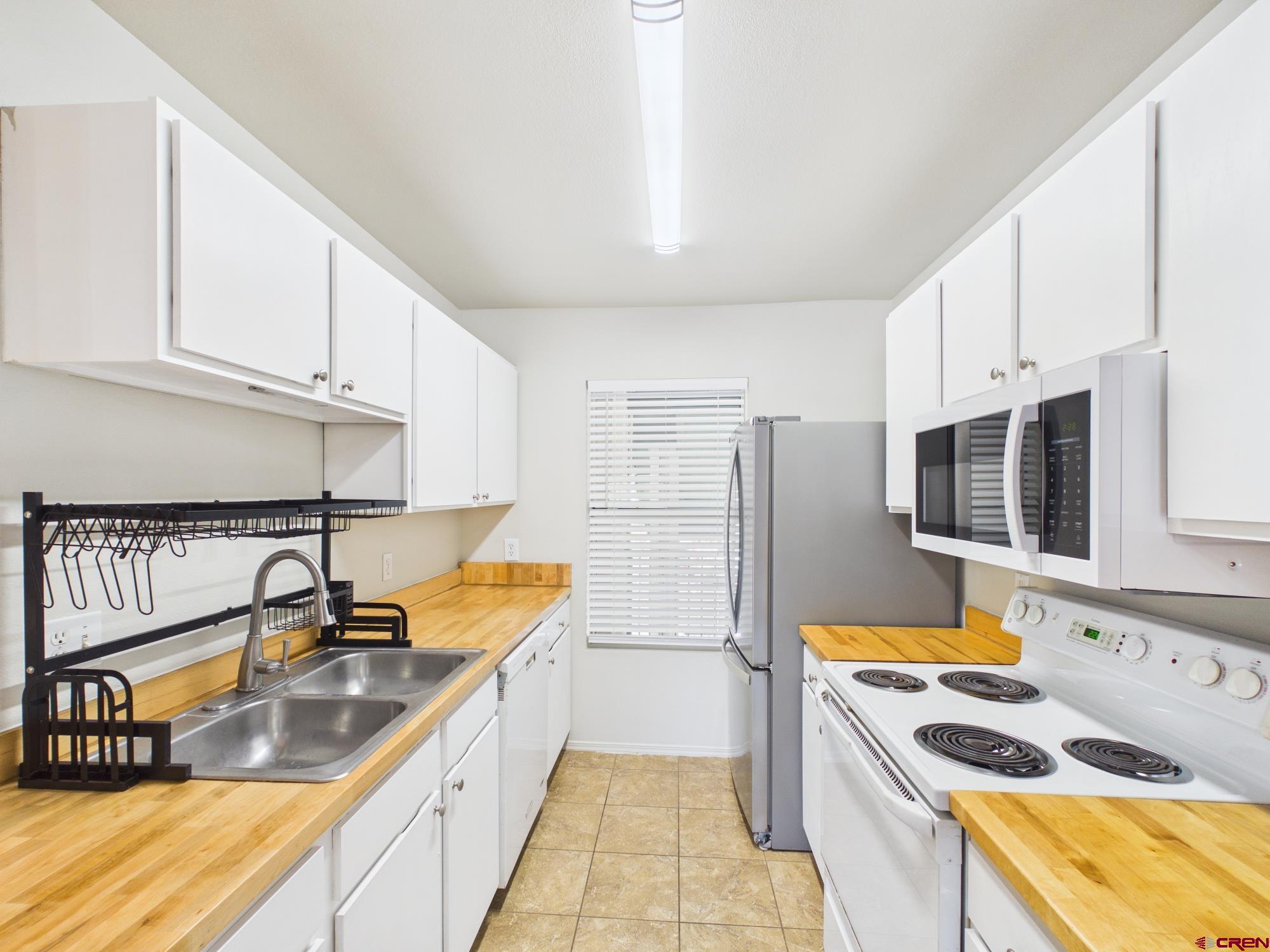 1100 Goeglein Gulch, Unit 216 Durango, CO 81301 - Photo 4 of 25 a kitchen with stainless steel appliances granite countertop a sink stove and refrigerator