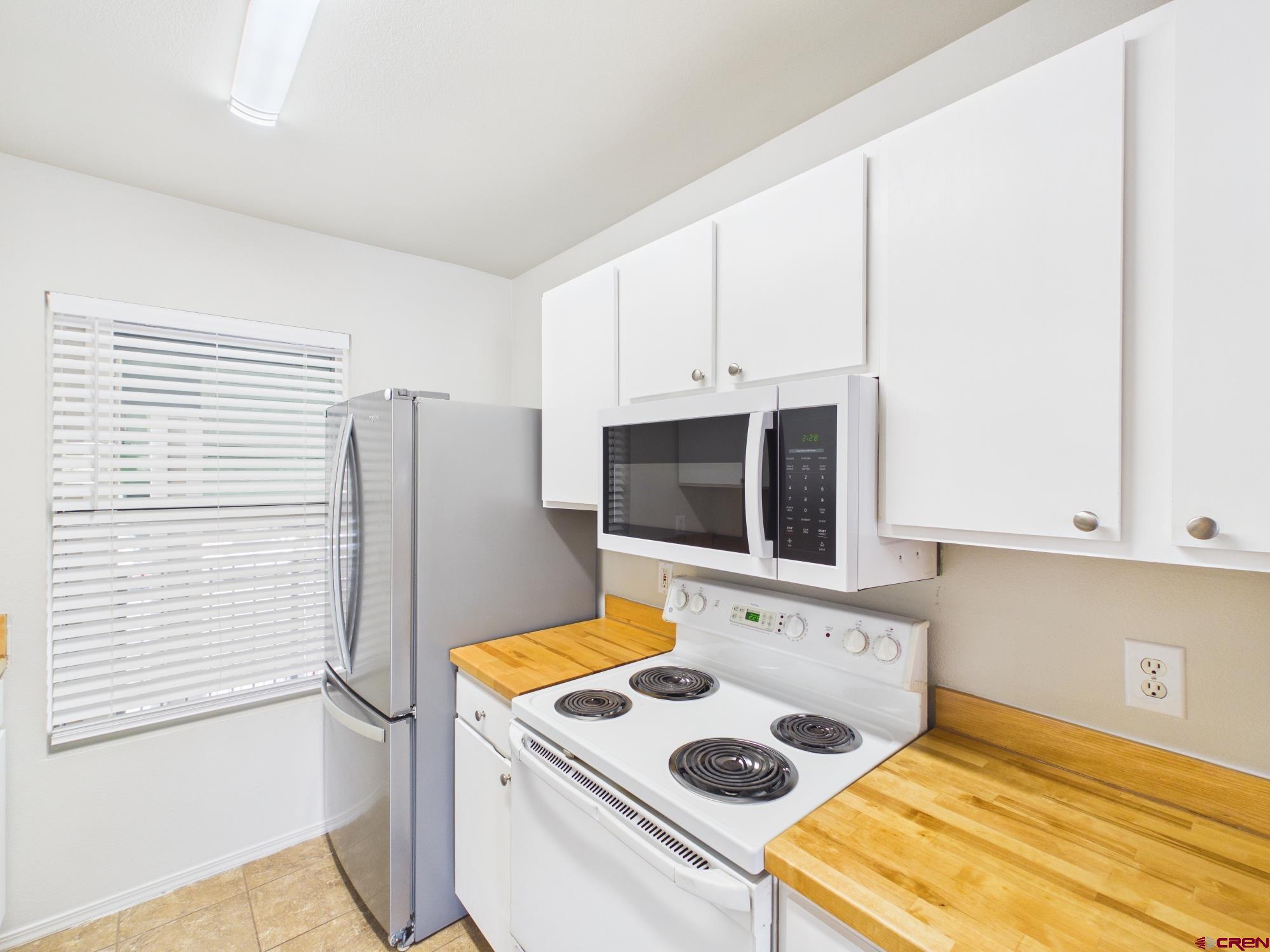 1100 Goeglein Gulch, Unit 216 Durango, CO 81301 - Photo 5 of 25 a bathroom with a sink a granite counter and a refrigerator