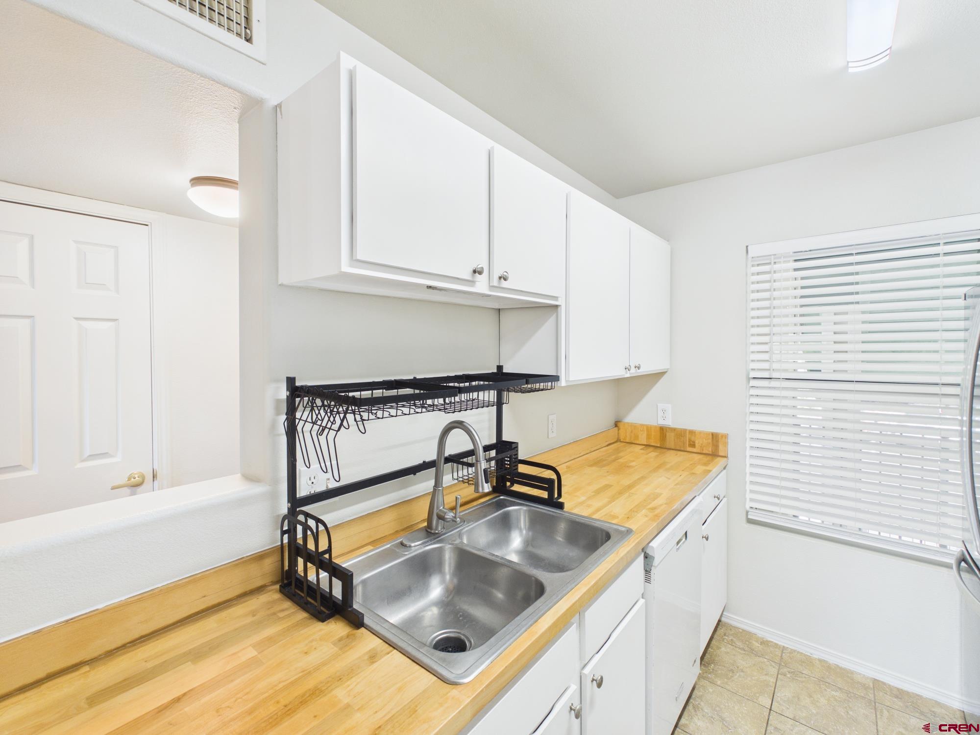 1100 Goeglein Gulch, Unit 216 Durango, CO 81301 - Photo 6 of 25 a kitchen with kitchen island a sink appliances cabinets and a counter top space